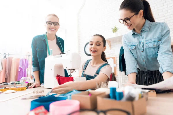 Three women at garment factory. They are choosing zippers for the dress. — Stock Photo, Image