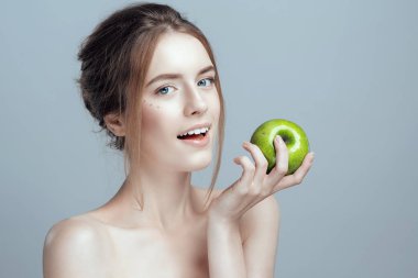 Onun elinde bir yeşil elma güzel bir kızla bir close-up fotoğraf. O temiz ve hatta cilt vardır.