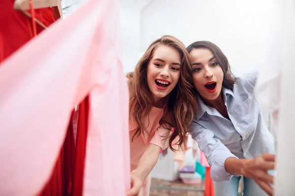 Twee jonge meisjes op winkelen. Meisjes kiezen kleding in de winkel. Meisjes in de showroom. — Stockfoto