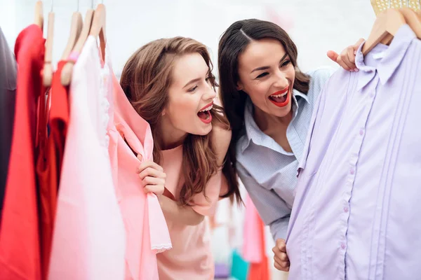 Две юные девушки за покупками. Девушки выбирают одежду в магазине. Девушки в выставочном зале . — стоковое фото