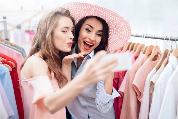 Dos chicas jóvenes de compras. Las niñas eligen la ropa en la tienda. Chicas en la sala de exposición . —  Fotos de Stock