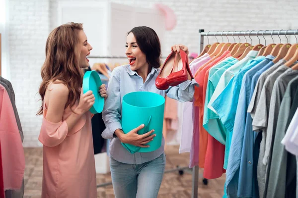 Dos chicas jóvenes de compras. Las niñas eligen la ropa en la tienda. Chicas en la sala de exposición . —  Fotos de Stock