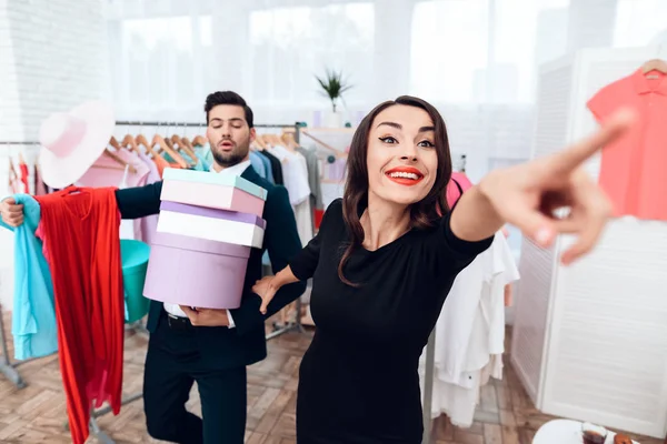 Mooi meisje in een jurk en een aantrekkelijke man in pak winkelt. Ze zijn in een lichte showroom. — Stockfoto