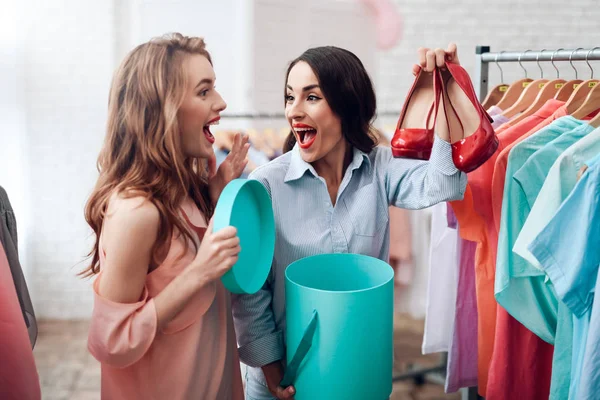 Dos chicas jóvenes de compras. Las niñas eligen la ropa en la tienda. Chicas en la sala de exposición . —  Fotos de Stock