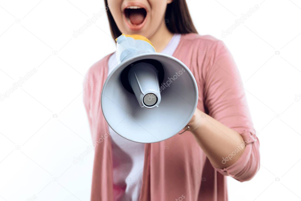 Young girl speaks into megaphone. Female activist. Isolated on white background. Studio portrait. Loud. Announcement
