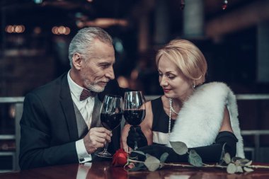 İş kadını ve iş adamı. Eski iş adamları. Başarılı yaşlılar. Birlikte sakin ol. Romantik toplantısı, zengin insanlar. Restoranda oturan bir çift. Lüks hayat. Birbirlerine bakıyorlar. alkış