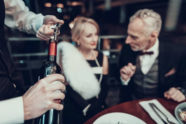 女商人和商人 老商人 成功的老人 一起放松 浪漫的会议 夫妇在餐厅休息 奢华的生活 服务人员 服务员打开酒 — 图库照片