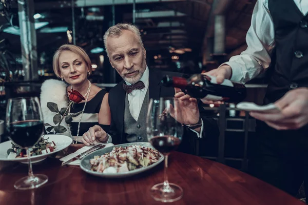 女商人和商人 老商人 成功的老人 一起放松 浪漫的会议 夫妇在餐厅休息 奢华的生活 服务人员 看看葡萄酒 — 图库照片