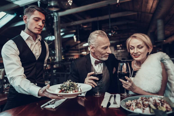 女商人和商人 老商人 成功的老人 一起放松 浪漫的会议 夫妇在餐厅休息 奢华的生活 服务人员 服务员带来的菜肴 — 图库照片