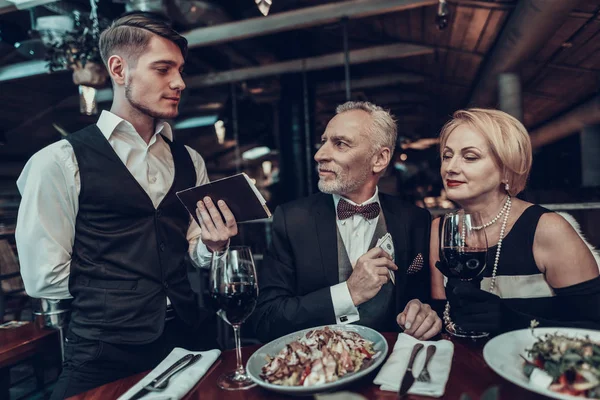 女商人和商人 老商人 成功的老人 一起放松 浪漫的会议 夫妇在餐厅休息 奢华的生活 服务人员 服务员带来账单 — 图库照片