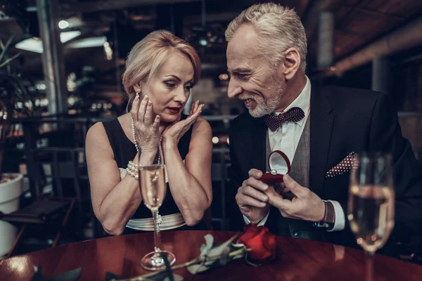 Businesswoman and Businessman . Old Business People .Successful Old People. Relax together. Romantic Meeting, Rich People. Couple Resting in Restaurant. Luxury Life. Man gives ring to woman