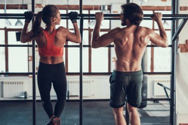 Adam ve bir kız çekme yapıyorsun Ups spor salonunda. Training Day. Fitness Kulübü. Sağlıklı bir yaşam tarzı. Güçlü atlet. Aktif tatiller. CrossFit kavramı. Omurga eğitim. Germe geri. Arkadan görünüm.