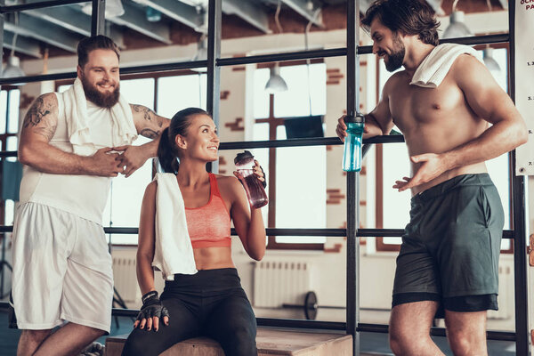 Two Guys And Girl Are Resting On Horizontal Bars. Training Day. Fitness Club. Healthy Lifestyle. Powerful Athlete. Active Holidays. Crossfit Concept. People Communication. Having Break.