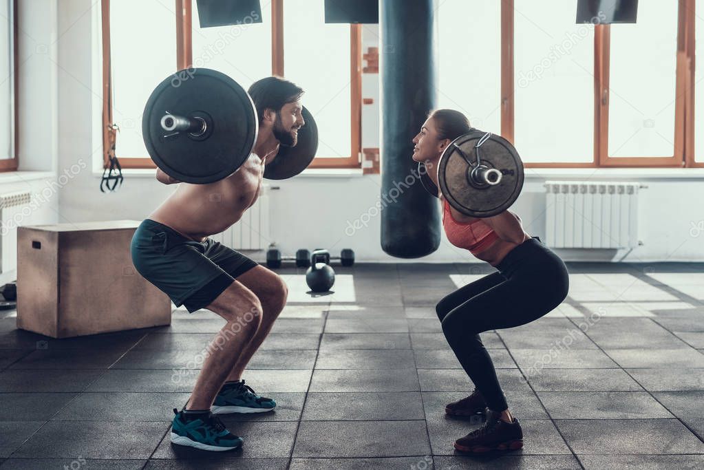 Man And Woman Are Lifting Barbells. Training Day. Fitness Club. Healthy Lifestyle. Powerful Athlete. Active Holidays. Crossfit Concept. Bright Gym. Working Out Together. Sportive Couple.