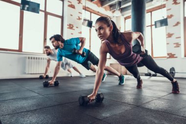 Sporcular yerde. Tek elle halter kaldırma. Training Day. Fitness Kulübü. Sağlıklı bir yaşam tarzı. Güçlü atlet. Aktif tatiller. CrossFit kavramı. Parlak spor salonu. Rahat spor giyim.