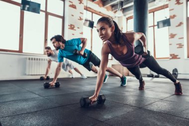 Sporcular yerde. Tek elle halter kaldırma. Training Day. Fitness Kulübü. Sağlıklı bir yaşam tarzı. Güçlü atlet. Aktif tatiller. CrossFit kavramı. Parlak spor salonu. Rahat spor giyim.