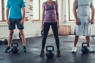 Sporcular ağırlıkları önünde dur. Alt görünümü. Training Day. Fitness Kulübü. Sağlıklı bir yaşam tarzı. Güçlü insanlar. Aktif tatiller. CrossFit kavramı. Parlak spor salonu. Rahat spor giyim. Hiçbir yüzler.