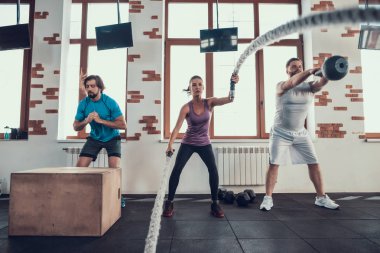 İp egzersiz ve ağırlık kaldırma atlar. Training Day. Fitness Kulübü. Sağlıklı bir yaşam tarzı. Güçlü atlet. Aktif tatiller. CrossFit kavramı. Rahat spor giyim. İki erkek ve kız.