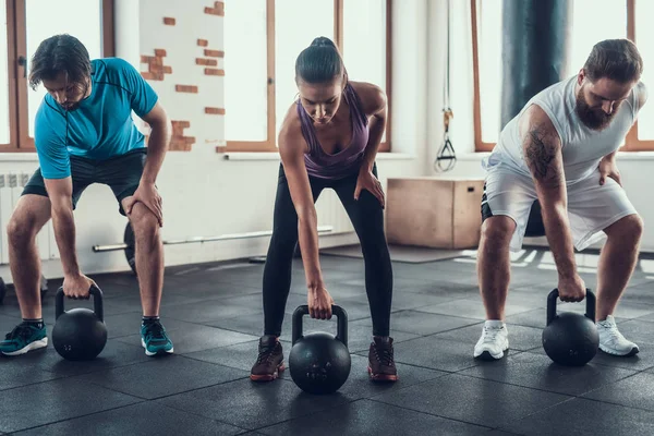 女孩和两个男人举起重量 培训日 健身俱乐部 健康的生活方式 强大的运动员 活动假期 交叉的概念 明亮的健身房 舒适的运动装 坚强的人 — 图库照片