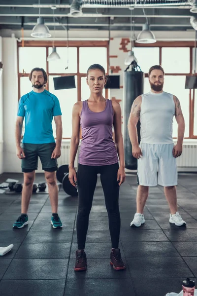 女性和两个男性 体育小组 在相机上摆姿势 培训日 健身俱乐部 健康的生活方式 强大的运动员 活动假期 交叉的概念 明亮的健身房 — 图库照片