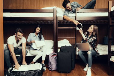Hostel genç insanlar için. Seyahat arkadaşlarım. Hostel küçük odada. Birlikte vakit. ranza yatak odasında. gülümseyen insanlar. İletişim. Koltuk işgal. Otur ve yatağa uzan. Bagaj açmak