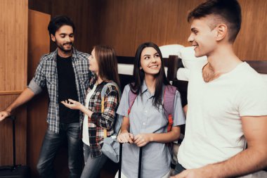 Hostel genç insanlar için. Seyahat arkadaşlarım. Hostel küçük odada. Birlikte vakit. Birbirlerine bakıyorlar. büyük bagaj. Omuzlarında sırt çantaları. ranza yatak odasında. gülümseyen insanlar. İletişim