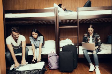 Hostel genç insanlar için. Seyahat arkadaşlarım. Hostel küçük odada. Birlikte vakit. ranza yatak odasında. gülümseyen insanlar. İletişim. Otur ve yatağa uzan. Bagaj açmak. çalışma ve dinlenme