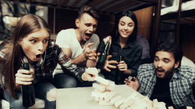 Hostel genç insanlar için. Seyahat arkadaşlarım. Hostel küçük odada. Birlikte vakit. gülümseyen insanlar. Yatağın üstüne oturan arkadaşlar. arkadaşlar portre. Jenga içinde oynamaya. her şeyi berbat