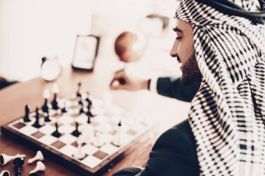 Arap iş adamı. Siyah takım elbise giyen adam. Deneyimli girişimci. Arap portresi başarılı genç adam. İyi eğlence. Arap satranç oynuyor. Strateji planlama adam. Adam oyun düşünüyor. arkadan