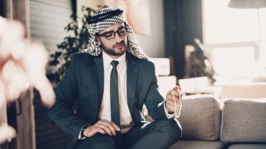 Arap iş adamı. Siyah takım elbise giyen adam. Deneyimli girişimci. Office, başarılı genç adam adet eser bulunmaktadır. adam holding telefon. kanepede oturan. Zinciri tutarak. zincir arıyorum. Arap portresi