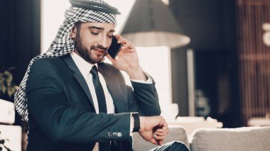 Arap iş adamı. Siyah takım elbise giyen adam. Deneyimli girişimci. Office, başarılı genç adam adet eser bulunmaktadır. konuşan adam. kanepede oturan. gülümseyen Arap. Şu andaki arıyorsunuz