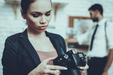 Dedektifler Özel Dedektiflik Bürosu 'nda çalışıyor. Dedektifler genç beyaz erkek ve kadın. Kadın kamerayı tutuyor. Adam Arkadaki İpucu Haritası 'nda duruyor. Kadın Ciddidir.