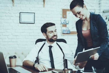 Dedektifler Özel Dedektiflik Bürosu 'nda çalışıyor. Dedektifler genç beyaz erkek ve kadın. Kadın, Tablet PC 'de erkeğe bir şey gösteriyor. İnsanlar gülümsüyor. Kılıflı adam..