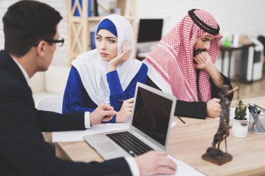 Avukat Arap karı koca ofiste takım elbiseli. Avukat kadınla konuşuyor.