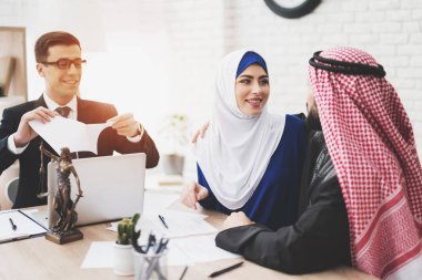 Avukat Arap karı koca ofiste takım elbiseli. Avukat boşanma belgelerini yırtılma. Çift mutludur.