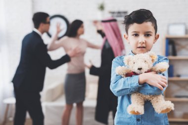 Arap karı koca ofiste takım elbiseli boşanma avukatı. Oğlum oyuncak ayı ile duruyor, veliler tartışıyor.