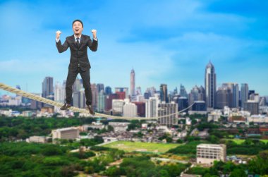 Bir ip üzerinde duran işadamı cityscape bulanık.