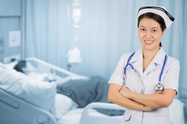 Asian nurse with stethoscope on background blur patient room.