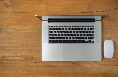 Laptop ve fare üstünde okul sırası, üstten görünüm.