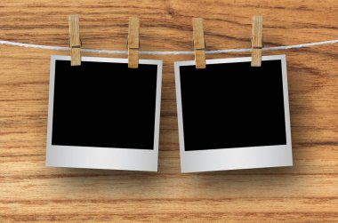 Kırpma yolu ile ahşap arka plan asılı clothespin ile boş fotoğraf çerçevesi.