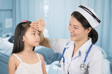 Tek tip sıcaklık ölçümlerde Asyalı hemşire misin kızlarla arka plan bulanıklık hasta odası.