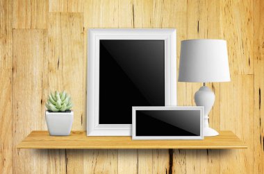 Kitaplık - ürün görüntü için üzerinde yol, lambalar ve saksı kaktüs kırpma ile izole boş resim çerçevesi.