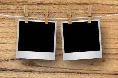 Kırpma yolu ile ahşap arka plan asılı clothespin ile boş fotoğraf çerçevesi.