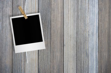 Kırpma yolu ile ahşap arka plan asılı clothespin ile boş fotoğraf çerçevesi.