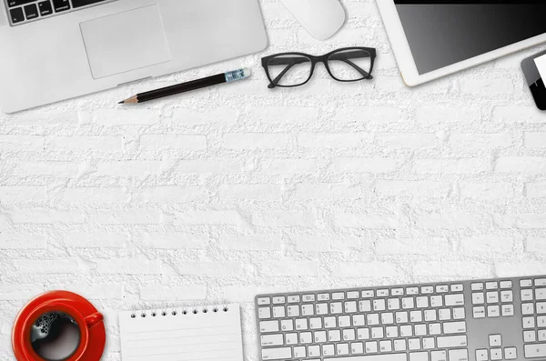 Office desk table with laptop, mouse, digital tablet, notepad, pencil and coffee cup, Top view with copy space.