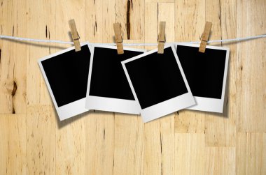 Kırpma yolu ile ahşap arka plan asılı clothespin ile boş fotoğraf çerçevesi.