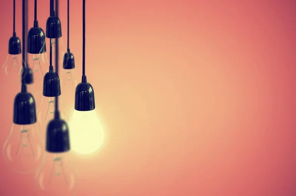 Idea concept with light bulb on the background pink color. Vintage Style.