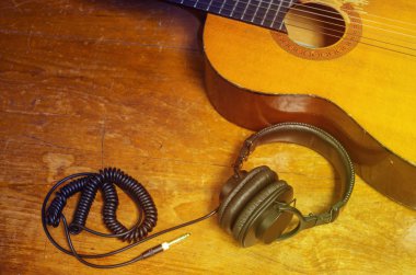 Akustik gitar ve kulaklık eski ahşap tablo.