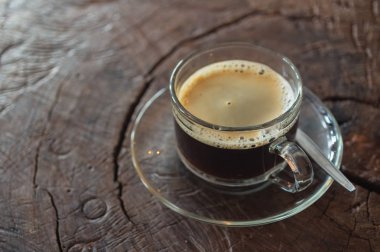 Bir kafede ahşap bir masa üzerinde siyah kahve fincanı.