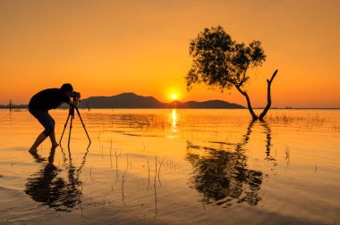 Gün batımı Chon Buri Bang Phra rezervuar çekim fotoğrafçı silüeti.
